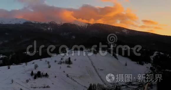 冬季日落时积雪覆盖的高山和森林的鸟瞰图