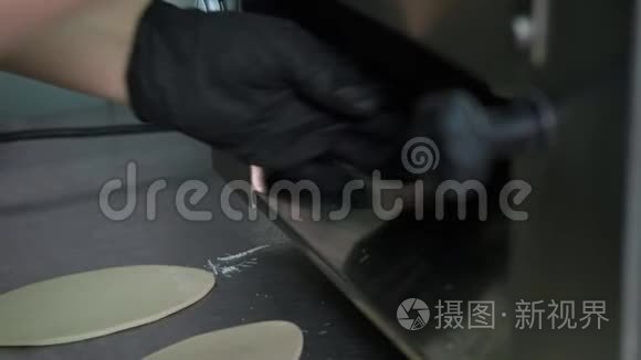 用擀面机将厨师的双手擀出面团. 厨房制作Khinkali的过程..