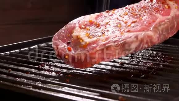 加胡椒的生肉牛排放在烤架上视频