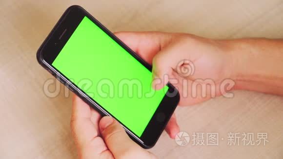 男人手里拿着智能手机，手里拿着绿色屏幕，手里拿着带有色度键的手机。 白色背景