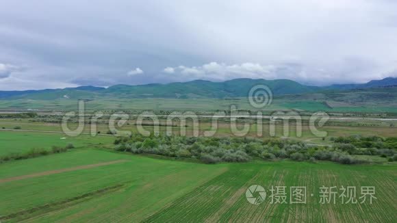 在多云的春日鸟瞰农田和青山视频