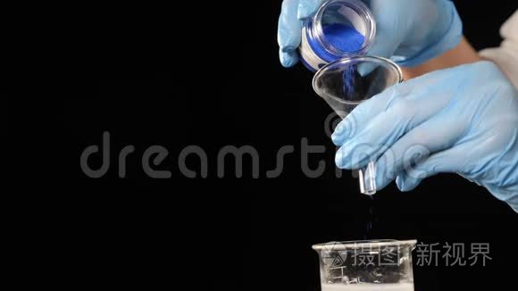 在化妆品或香水生产的化学实验室。 实验室工人倒蓝色的化学物质，香水
