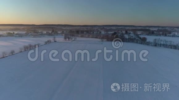 清晨日出的鸟瞰美丽乡村落雪后视频