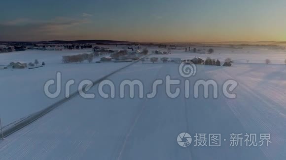 清晨日出的鸟瞰美丽乡村落雪后视频