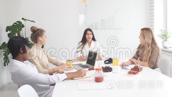 年轻的商务女士在白色办公室的商务会议上，在咖啡休息时与人互动