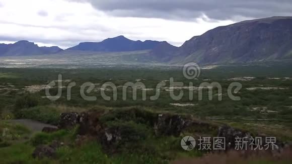 在崎岖的地形下，孤独的道路上独自一人行驶冰岛山岸线的车辆