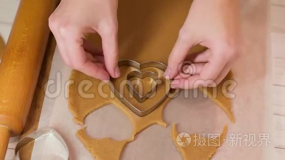 女人在桌上用心形刀切姜饼面团视频