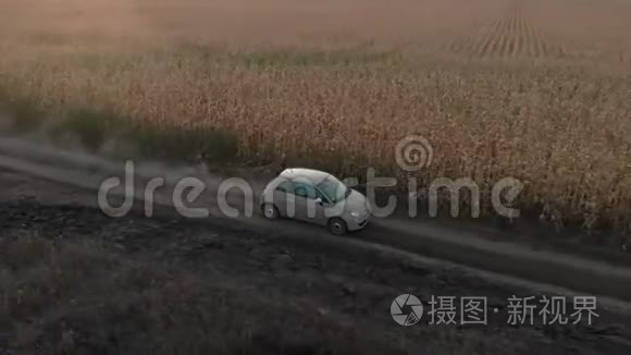 一辆小型自行车正行驶在靠近玉米地的乡间尘土飞扬的道路上