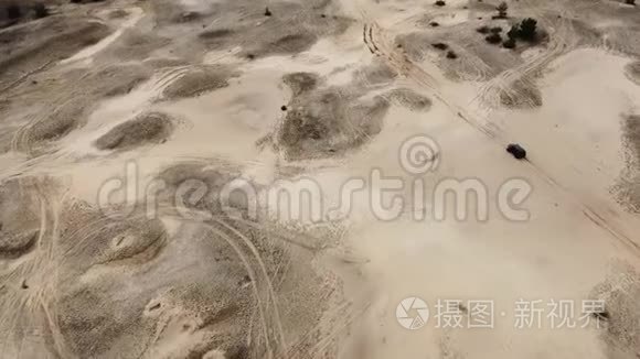 空中飞行。 黑色越野车骑在沙地路上。 上景。