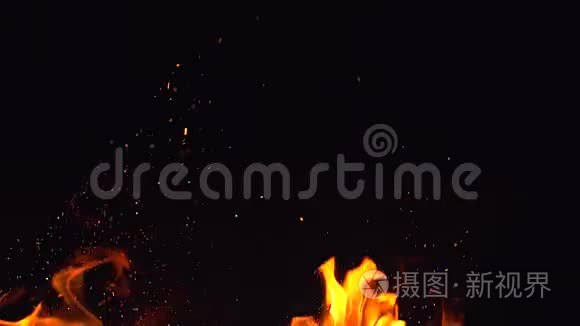 火苗和许多明亮的火花在夜晚从火中飞来