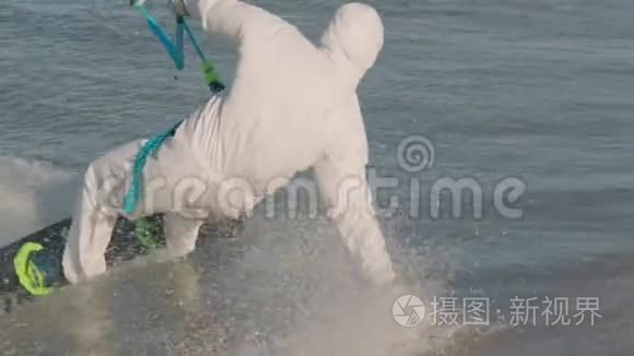 穿着医用个人防护装备的男子在海洋风筝冲浪，极限夏季运动慢动作。 病毒