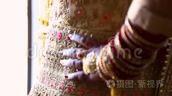 印度新娘的特写，用传统的礼仪用的犹太餐具和指甲花装饰。 108024FPS