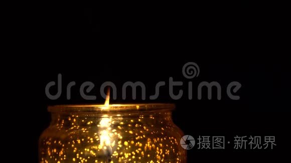 烛台上的蜡烛在黑色背景下燃烧视频