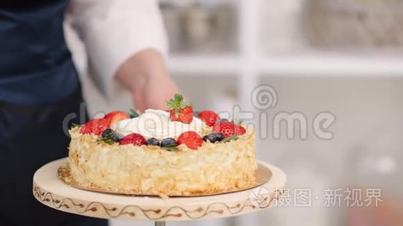 女厨师手在盘子上旋转的蛋糕上加入草莓。 近距离拍摄4k红色相机