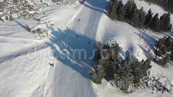 滑雪坡。 滑雪者和滑雪者滚下跑道. 一名滑雪者在宽阔的滑雪坡上的空中摄影