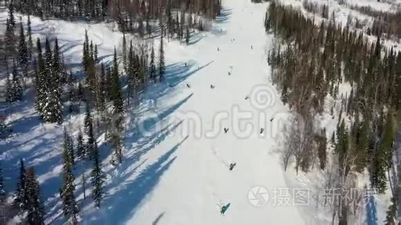 滑雪坡。 滑雪者和滑雪者滚下跑道. 一名滑雪者在宽阔的滑雪坡上的空中摄影