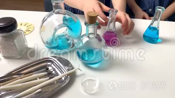 孩子们，小学的男孩，在玻璃瓶中用有色液体进行化学实验，这是一个科学的概念。 4公里