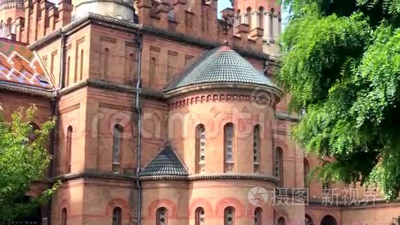 Chernivtsi国立大学宗教神学院的一座美丽的历史建筑，红砖立面，绿树成荫