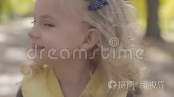 一个金发棕色眼睛的小可爱女孩的肖像，微笑着摇头。 快乐的白种人儿童