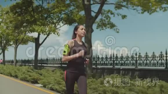 健身亚洲女子晨跑公园车道视频
