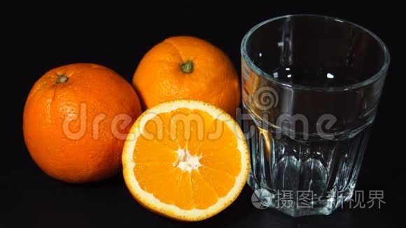 将橙汁倒入带有黑色背景的玻璃中