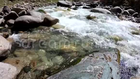 水在山间肆虐的河流中.. 美丽的石头和水的自然背景。 清澈的水和湍急的河流
