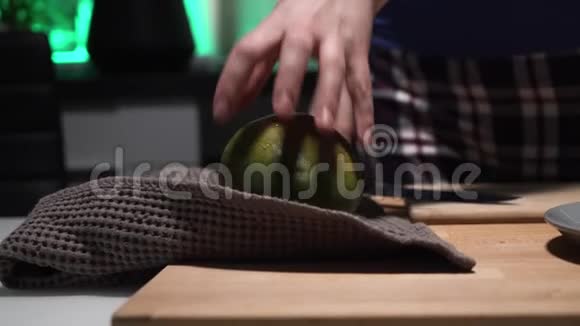 穿格子裤的女孩在厨房的木板上用大刀切芒果。视频的预览图