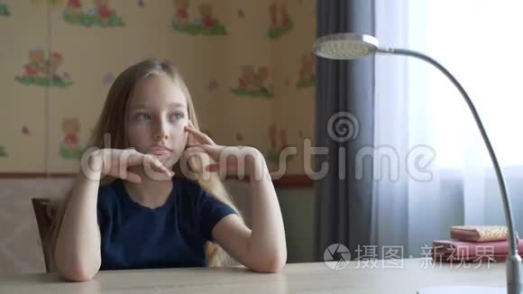 肖像体贴的少年女孩坐在家庭办公室的桌子上。 脸上沉思的少女在工作桌前思考