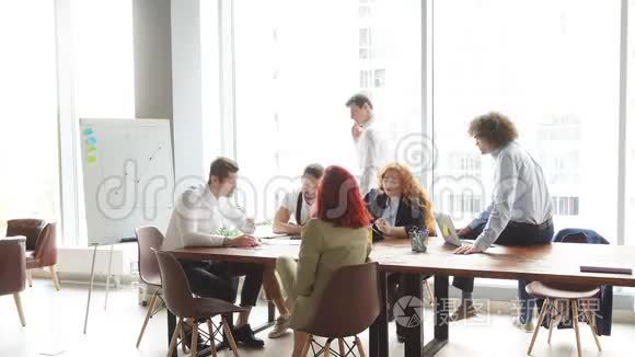 成功的多种族青年企业家团队在办公室共用一张桌子