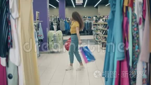 微笑的女人在服装店里拿着袋子旋转
