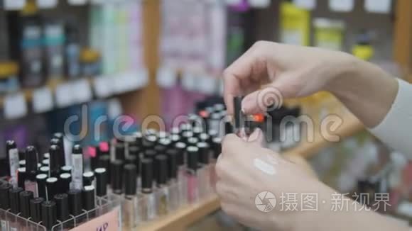在商店里买化妆品。 女人在商店里选择彩色化妆品。 女士使用化妆测试器。