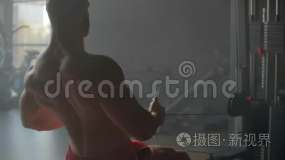 一个人坐在模拟器里，靠背肌肉做运动，把体重拉到肚子上