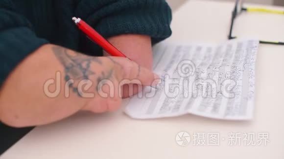 一个手上有解剖过程的人在纸上写一支带有文字的钢笔。