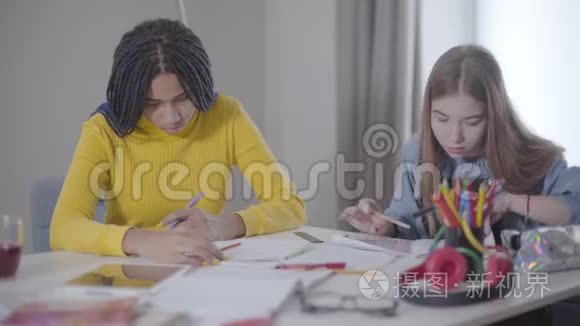 聪明的女学生坐着笔记本说话的肖像。 非裔美国人和高加索女孩
