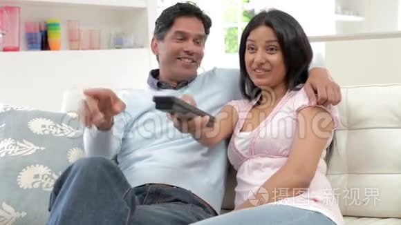 印度夫妇一起坐沙发看电视