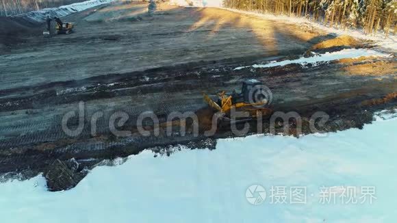 两台推土机平沙，在冬天修一条路。 砍伐森林，建设，发展新公路。 空中侧景。