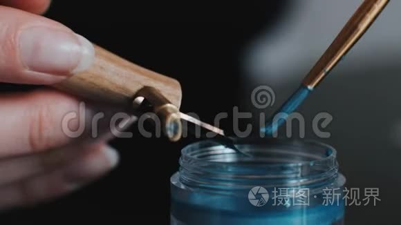 女孩用蓝色睫毛膏浸泡书法笔视频