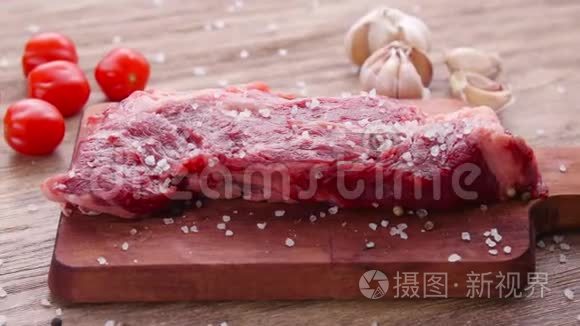 以草本植物和香料为背景的生鲜肉牛排