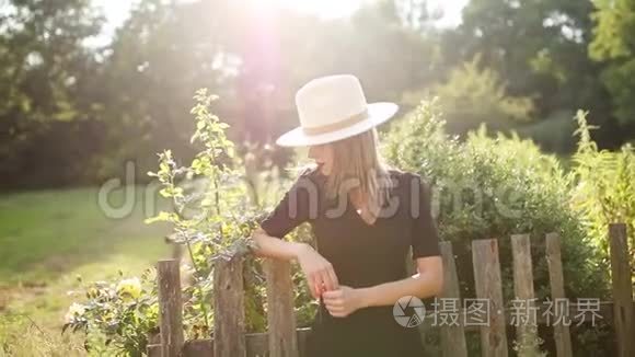 戴帽子的女人在夏天的乡村花园视频