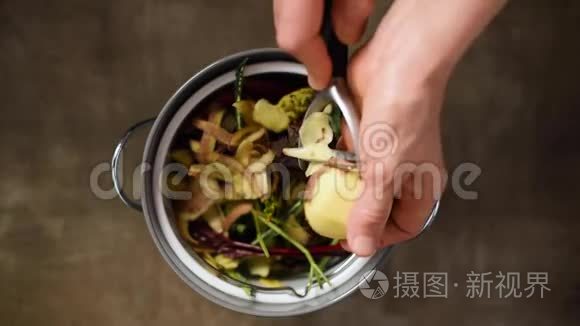 减少食物浪费。 妇女在堆肥桶里扔蔬菜剥皮纸屑和果皮。 上景。 分类