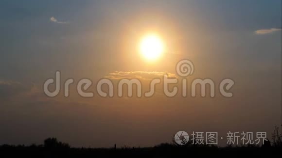 傍晚时分日落. 太阳落在地平线后面，树木的轮廓。 红色日落。