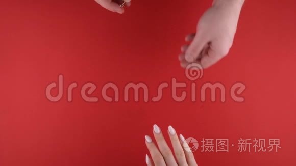 2月14日的求婚。 男人给女人戴上订婚戒指。 3月8日妇女节礼品