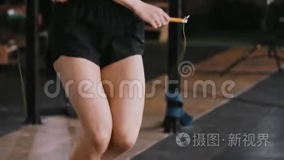 在健身房里用跳绳锻炼的年轻漂亮的金发女人。 过着积极的生活方式，慢动作。