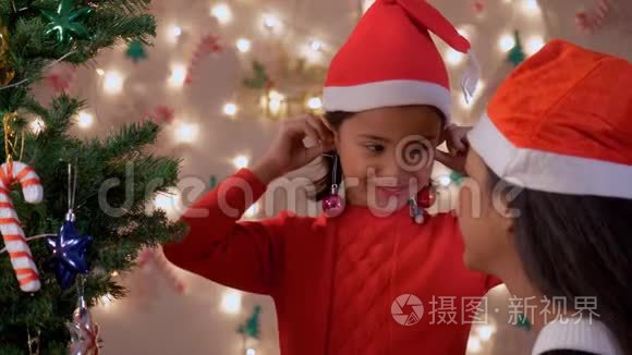 可爱的小女孩在玩，用圣诞装饰球做耳环