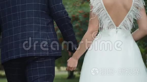 新婚夫妇手牵手在公园散步