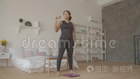 苗条的女人挣扎着吃垃圾食品视频