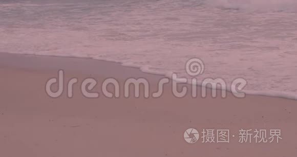 夕阳红沙滩上带泡沫的海浪视频