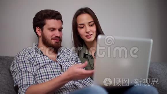 年轻的夫妇一起在笔记本电脑上看电影