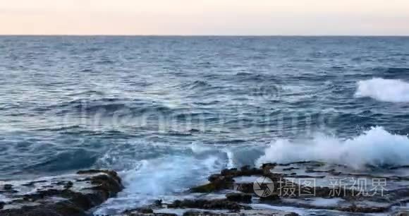 日落时有飞溅的波浪的地中海。 塞浦路斯岛上的海景。 4k视频4096X2160