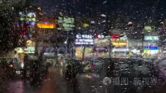 一辆停在雨中的汽车的挡风玻璃视图，从里面看。